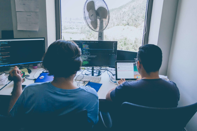 Two people pair programming at desk