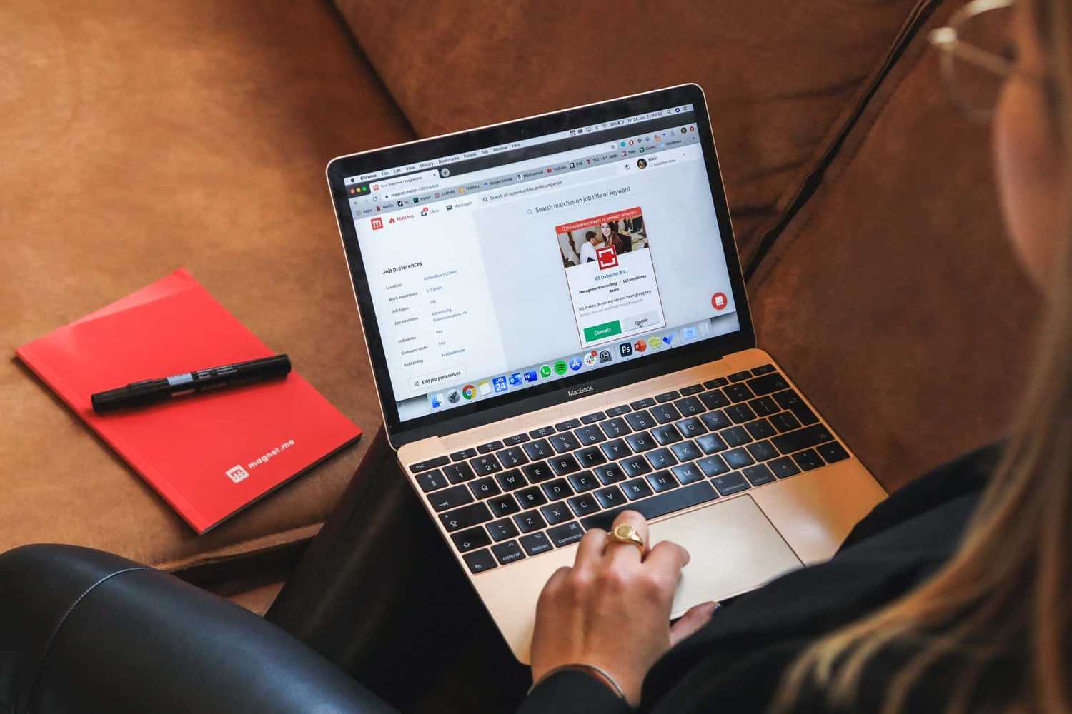 Person sitting on a sofa apply for jobs on a macbook