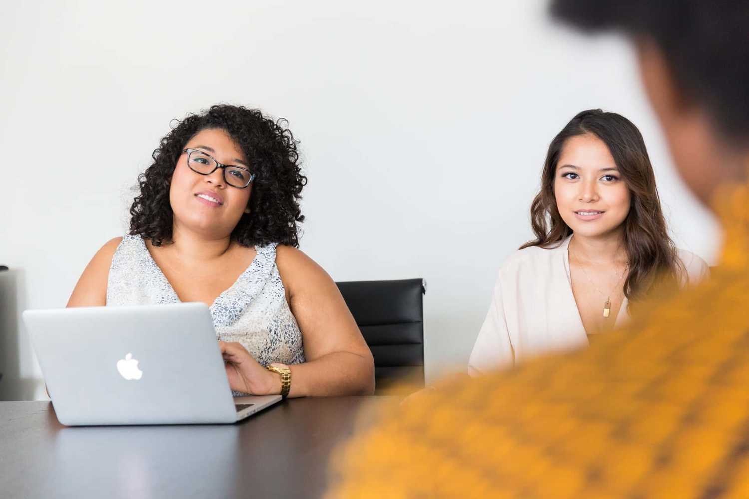 Two people looking at another person across a table